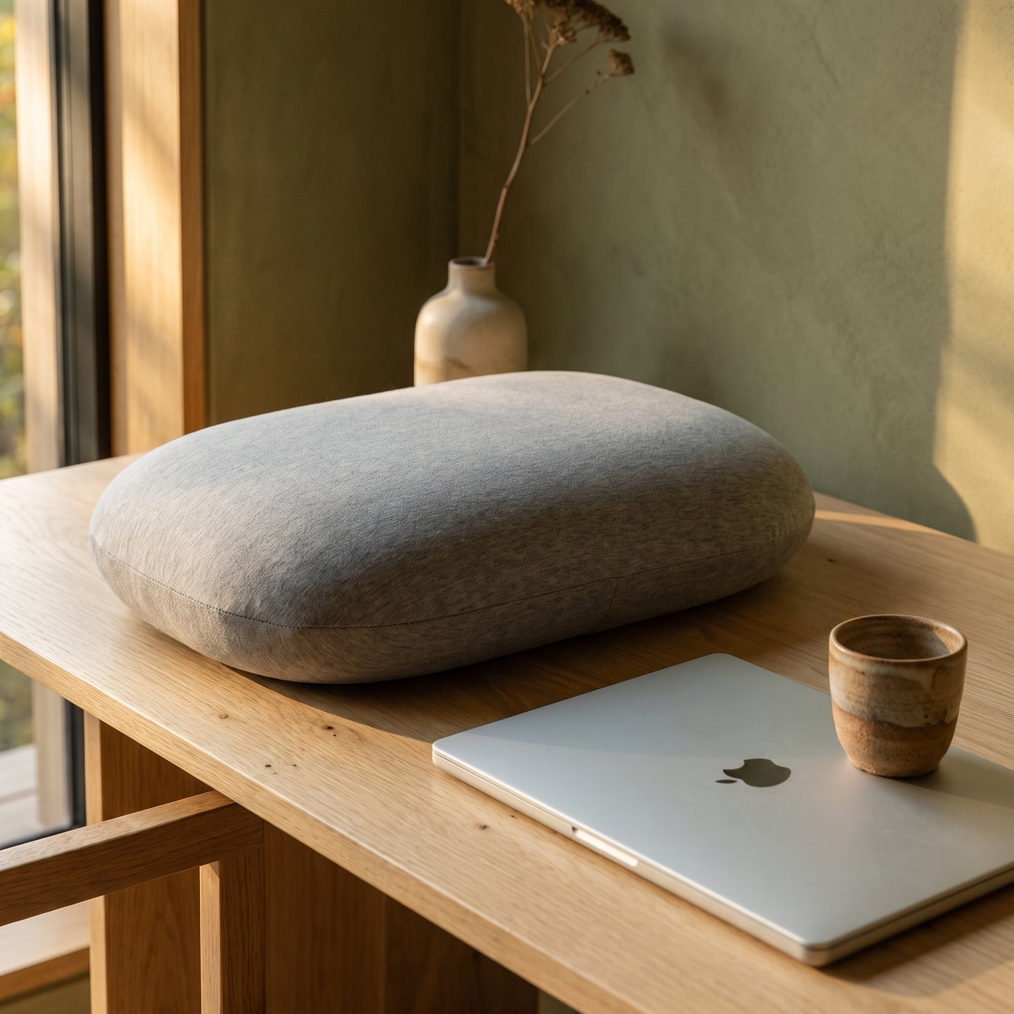 Doze™ Desk Nap Pillow resting on a pale-oak desk in the Kopflo interior