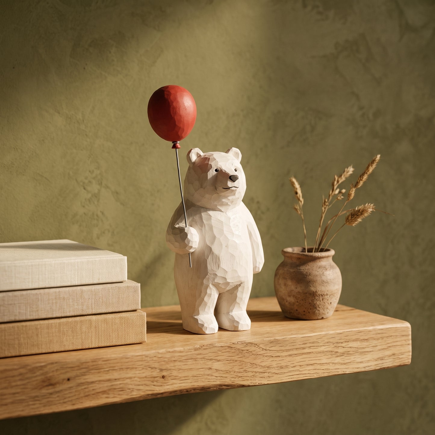 Bruin™ Carved Bear Ornament with red balloon on an oak shelf in Kopflo style