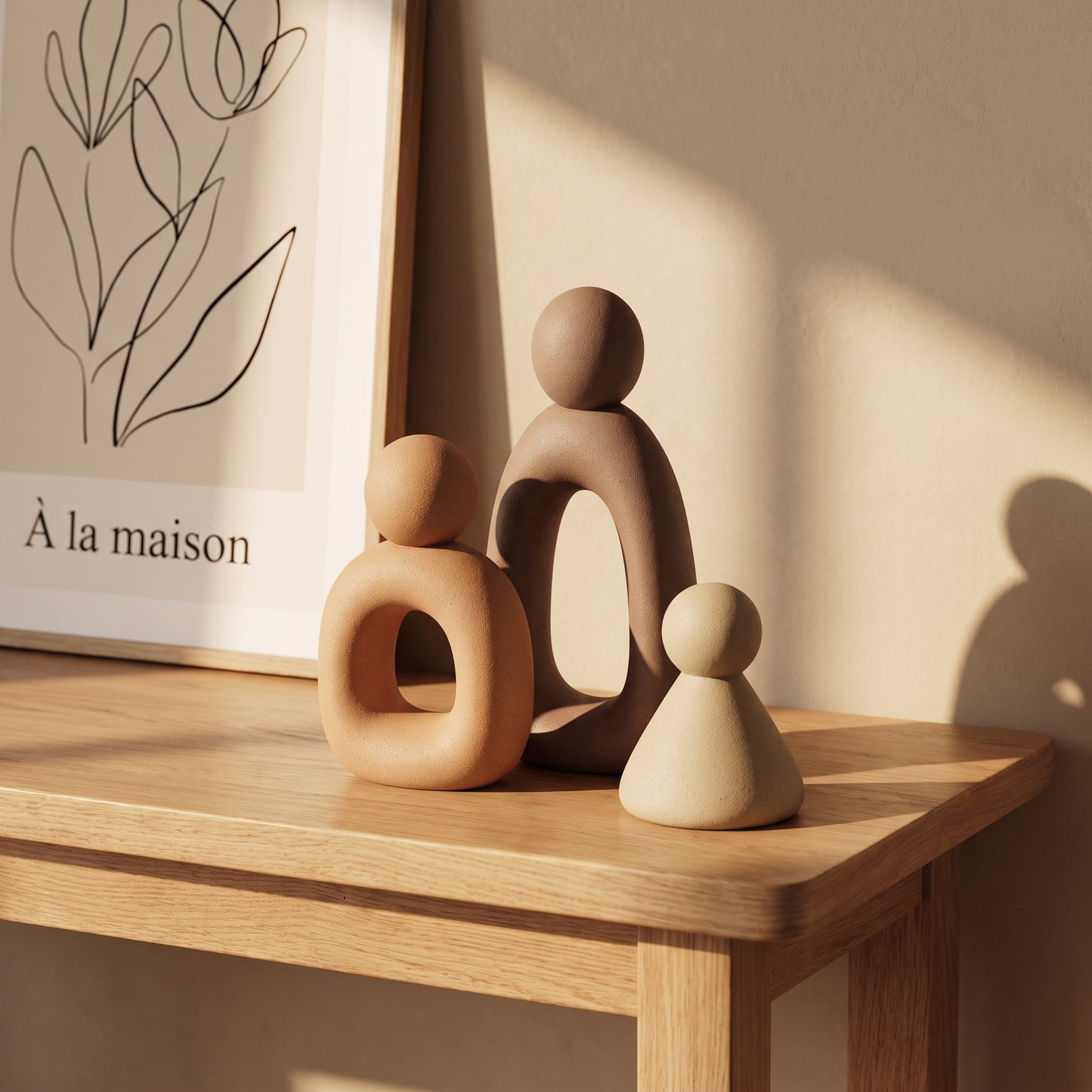 Kin™ Family Sculpture Set on an oak console beneath a line-art print