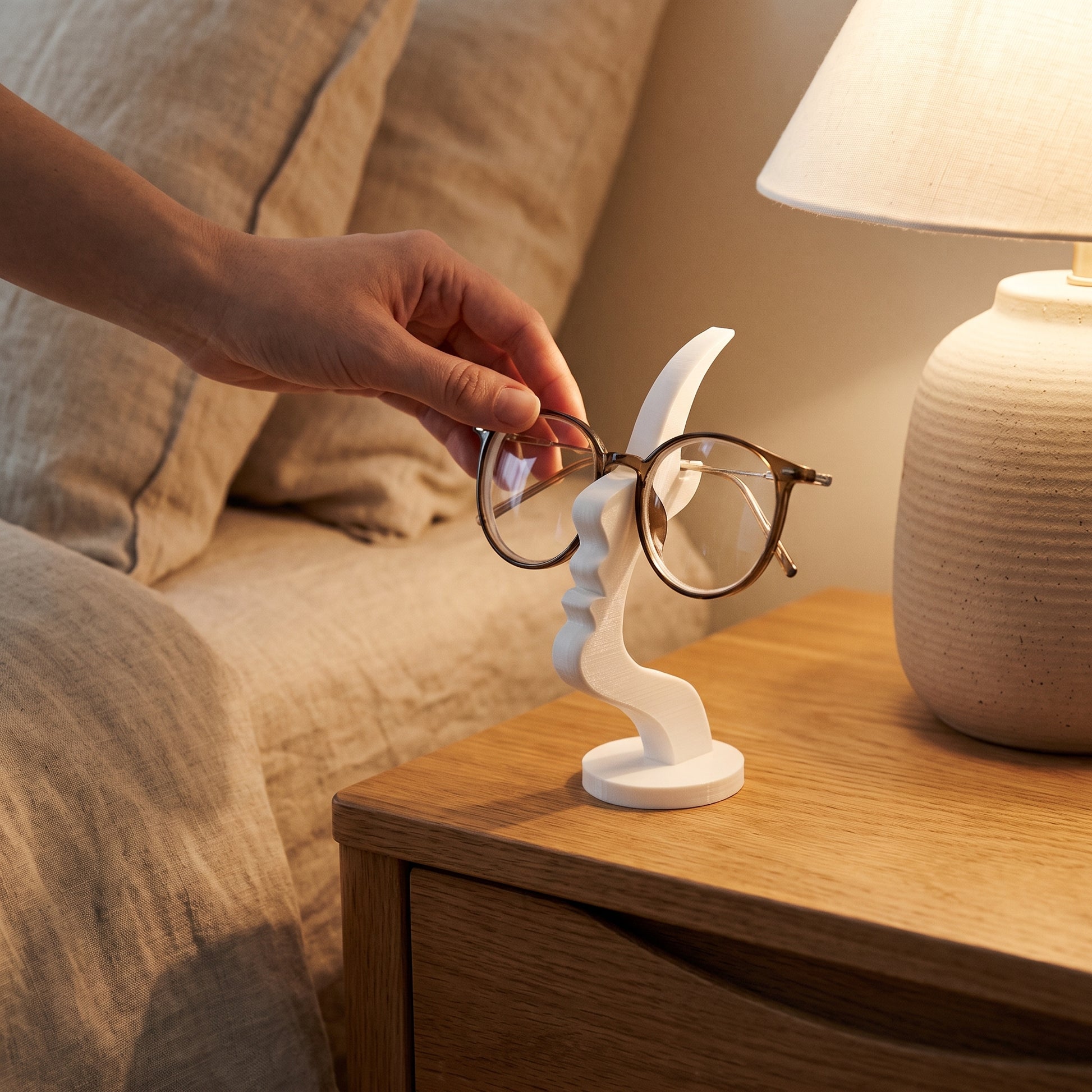 Placing glasses onto the white Visage™ Glasses Stand at bedtime