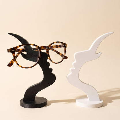 Visage™ Glasses Stand — black and white face-profile stands on warm cream background