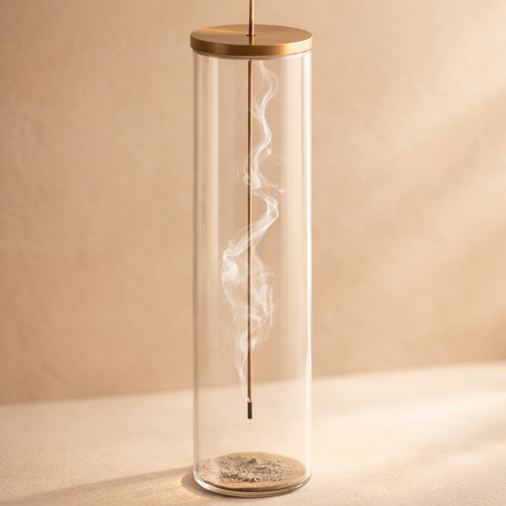 Chimney Incense Burner glass tube with brass lid on warm cream plaster