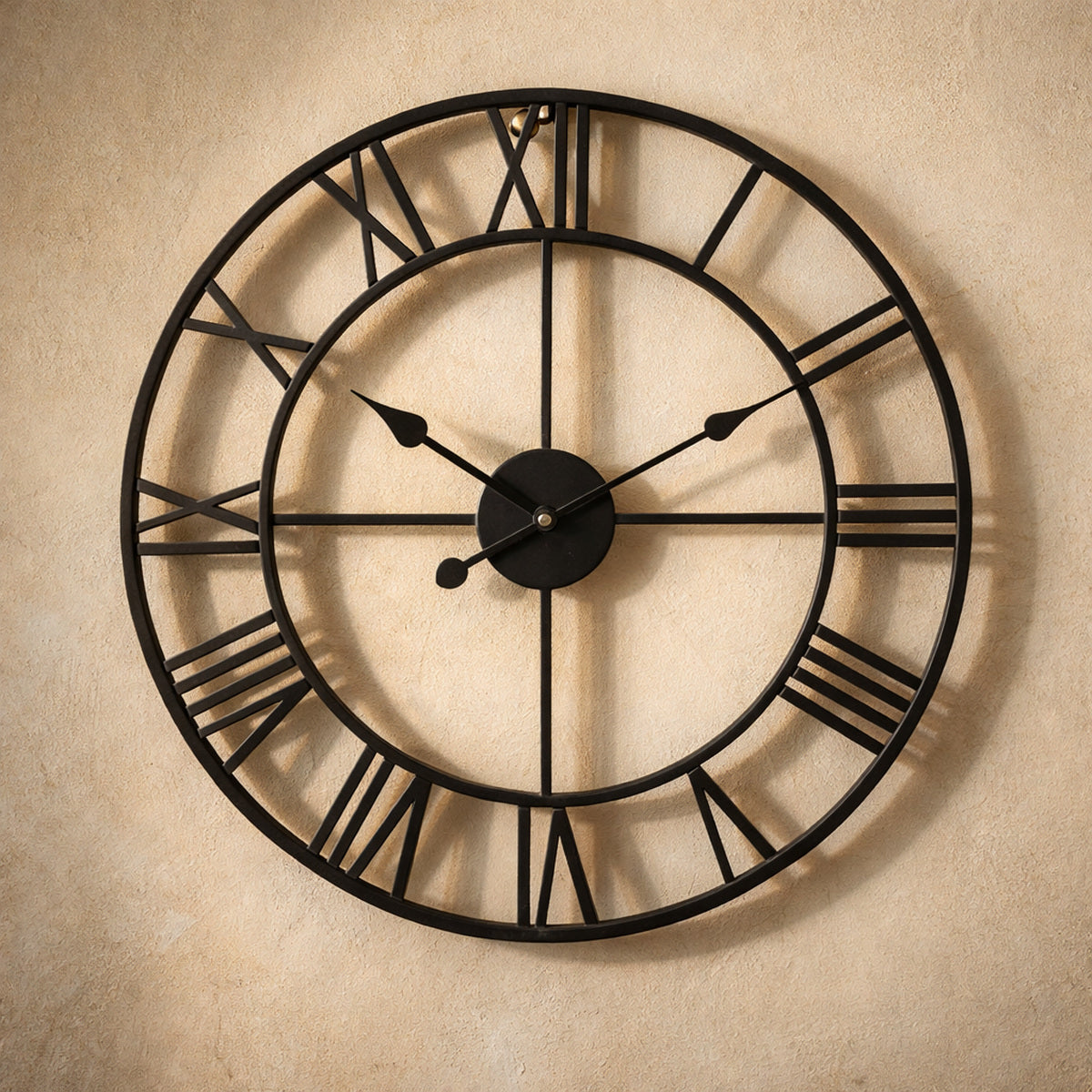 Forum wall clock in matte black on warm cream plaster, open skeleton iron frame with raised Roman numerals