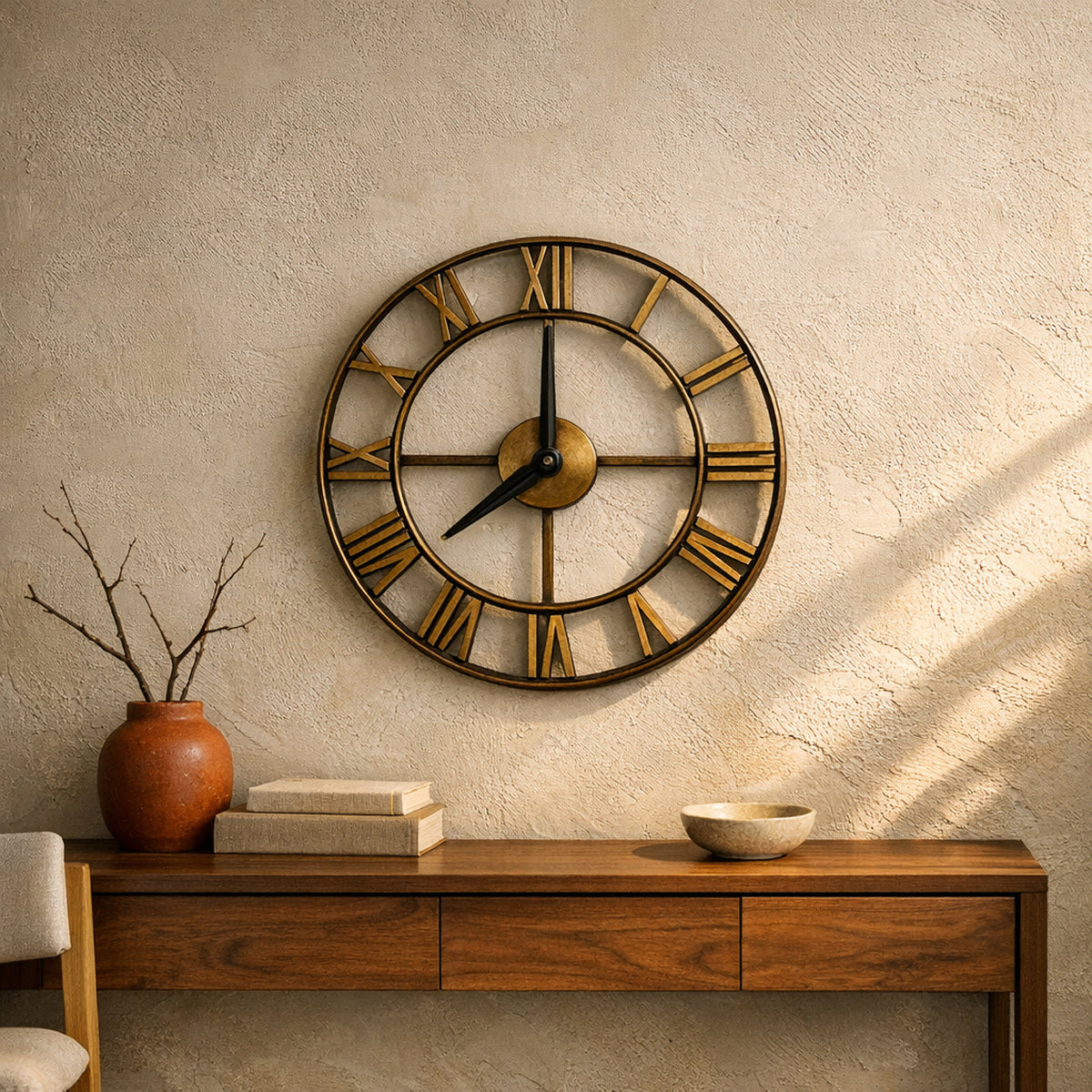 Forum wall clock in antique gold hung on a warm plaster wall above a walnut console table