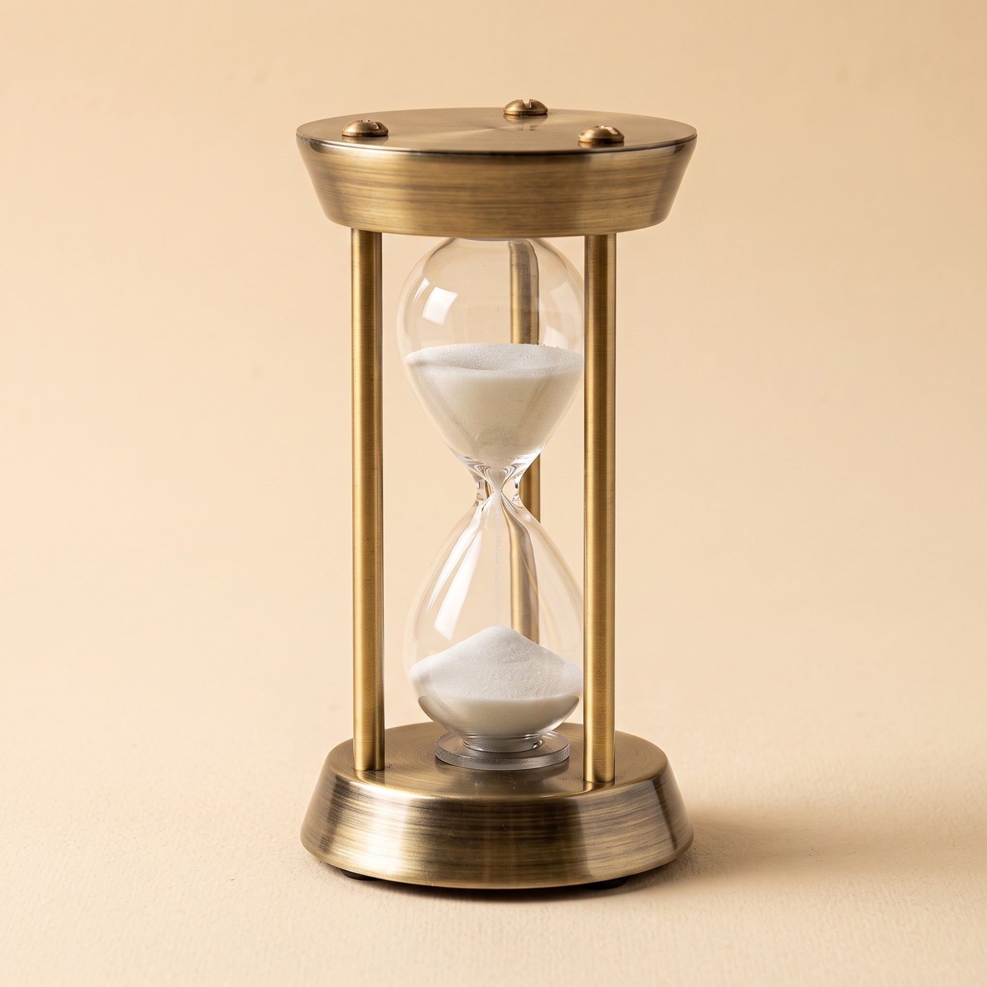 Ebb™ Sand Timer — antique brass frame with a hand-blown glass hourglass and white sand