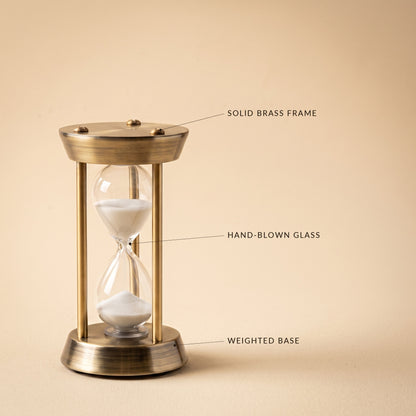 Ebb™ Sand Timer detail — solid brass frame, hand-blown glass, weighted base