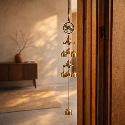 Peal chime hooked on the inside edge of a pale oak door frame in a warm Japandi entrance hall