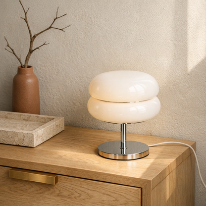 Sable lamp on a blonde oak console beside a travertine tray and terracotta vase in a modern minimalist room