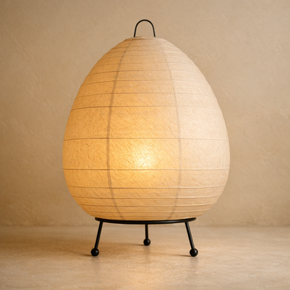 Shoji Paper Table Lamp — washi rice-paper shade glowing on a warm-cream plaster studio backdrop