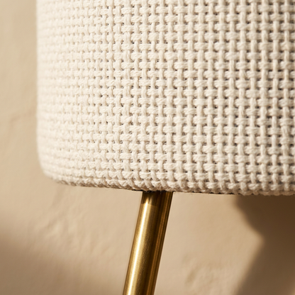 Close view of the open basketweave and the brass leg meeting the seat